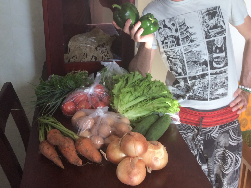 Curtiss poses with vegetables from the local outdoor market